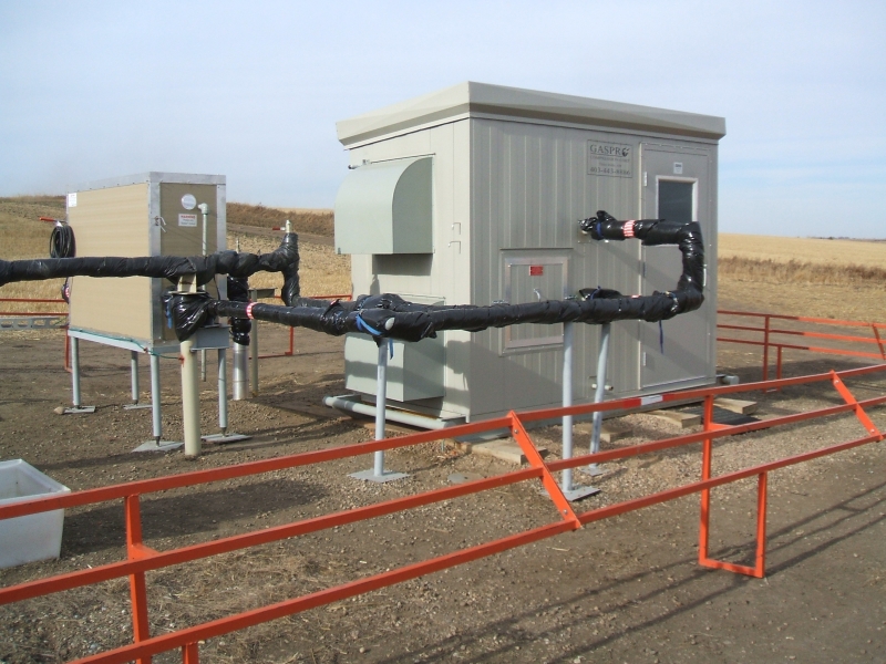 Natural gas compressor station with pipelines and control units in a rural field, showing how natural gas compressors work to pressurize gas for pipeline transport.