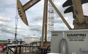 Oil and gas compressor station with pumpjack and compression equipment at an active energy site.