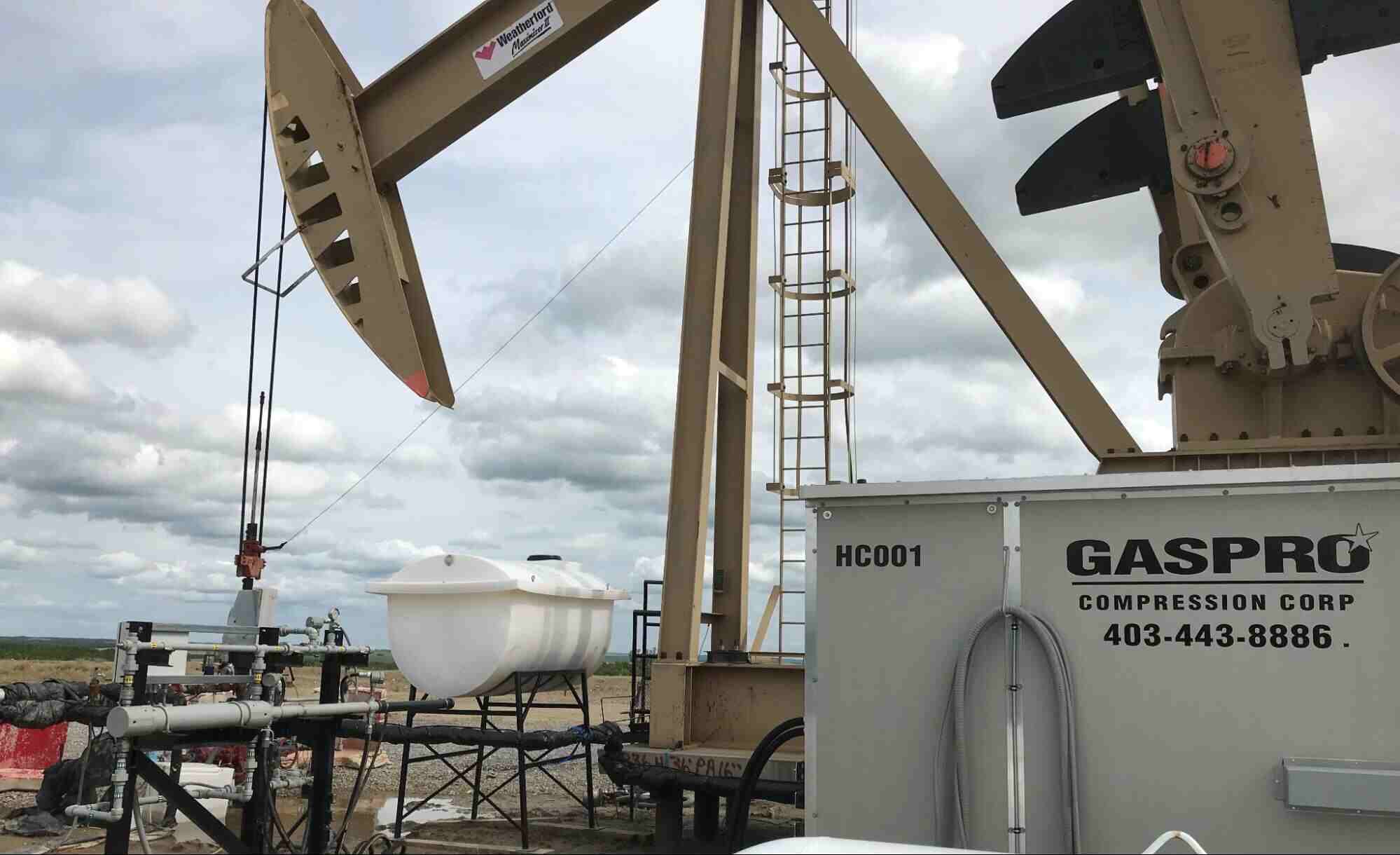 Oil and gas compressor station with pumpjack and compression equipment at an active energy site.
